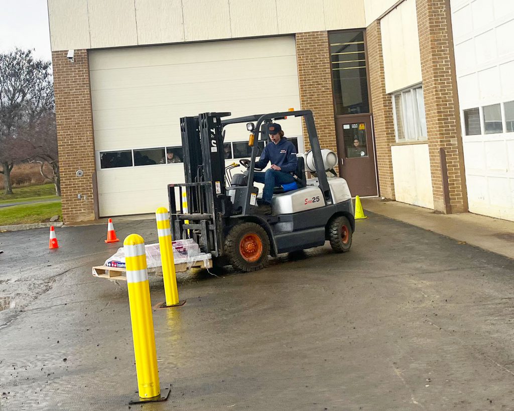 Teen operates a forklift.