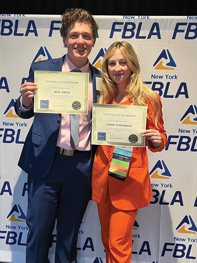 Two students posing holding their certificates for FBLA Honor Society