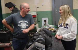 An instructor talking to a student in a welding class