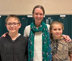 Amy Irwin stands between two grade 5 boys.