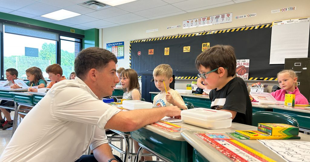 Teacher in classroom with students.