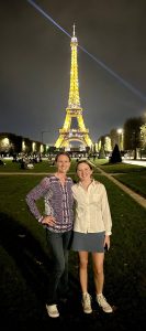 Amy Irwin and her daughter in front of the Eifel Tower at night.