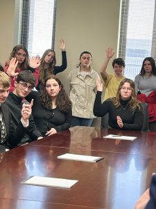 Students raising hands during discussion.