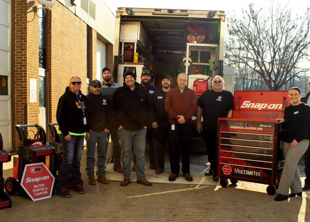 Students and teachers stand near Snap-on tools.