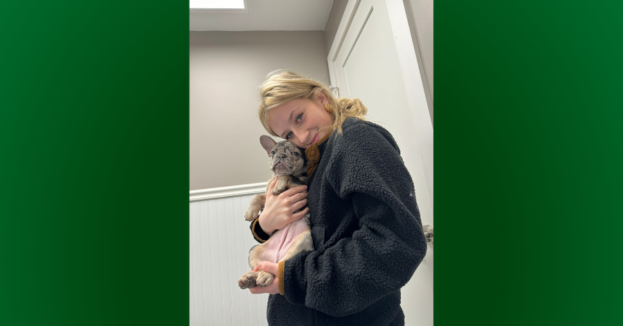 Teen holds cat close to her.