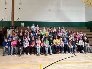 Students sit in stands.