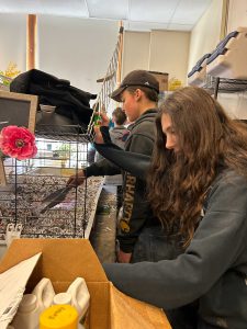 Students cleaning small-animal cages in classroom.