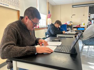 Principal takes exam with students in classroom.