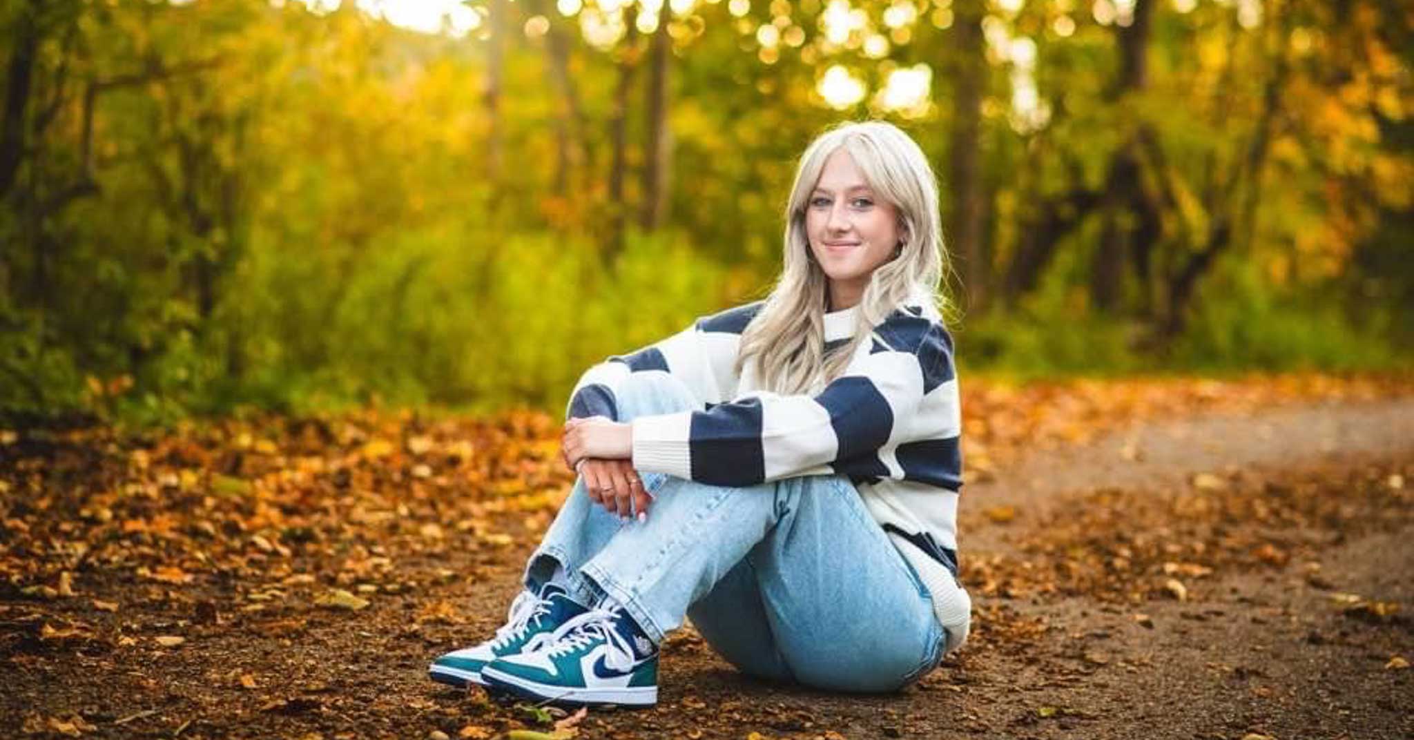 Student sitting. Forest in background