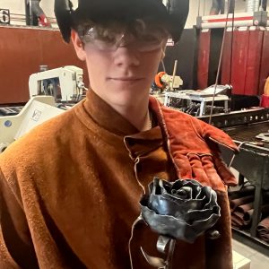 Student holds a welded rose.