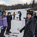 Students at bottom of a ski slope.