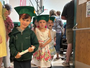 Children wearing kindergarten graduation caps.