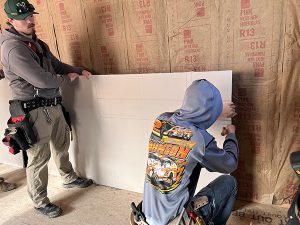 Two students work on masonry project.