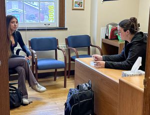 Student meets with college representative in school counseling office.