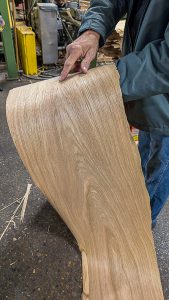 Man points at detail in wood grain strip.