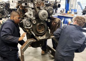 High school students work on an exposed engine.