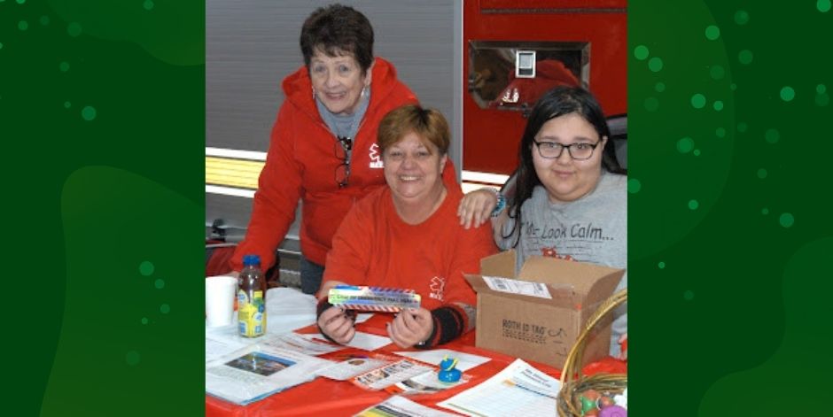 Two adults with teen. Table covered with papers and other materials.