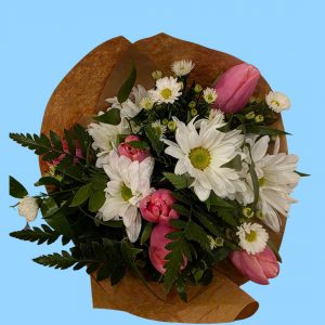 Floral arrangement featuring white daisies, pink tulips and lush greenery.