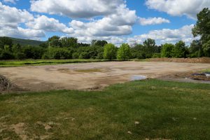 An empty field with a carved dirt platform.