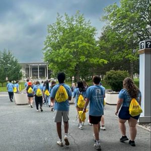 HOBY participants wearing blue-themed clothing walk on the SUNY Albany campus.