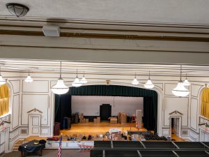 Auditorium stage undergoing renovation with equipment and materials in place.