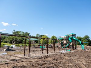 Playground equipment under construction on a newly graded site.