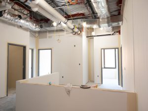 Health clinic interior under construction with utilities installed.