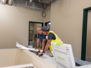 Construction team reviewing plans inside a renovation area.
