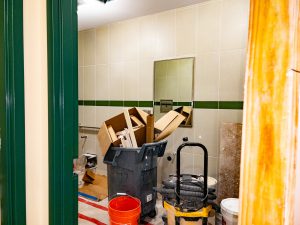 Bathroom renovation area with demolition debris and equipment.