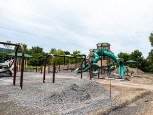 Playground construction with new equipment and surfacing in progress.