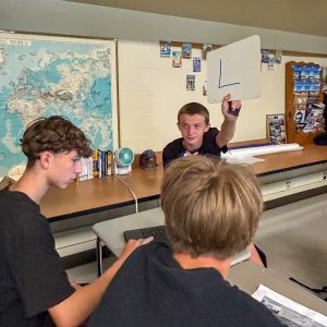 Students participate in a Constitution Day activity as one student holds up a whiteboard to share an answer during a classroom discussion.