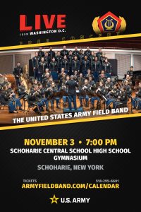 A vertically oriented event poster with a black textured background and gold diagonal accents promotes a free performance by The United States Army Field Band. At the center is a large color photograph of a military concert ensemble performing onstage. The ensemble includes a full concert band seated with woodwind, brass, and percussion instruments, a conductor facing the musicians, and a choir standing on risers behind them. All performers wear matching dark military dress uniforms with gold trim. Above the photo are the words "LIVE from Washington D.C." and a crest featuring a lyre symbol surrounded by gold laurel leaves. Below the image, large text announces: "The United States Army Field Band." Event information states: "November 3 • 7:00 PM, Schoharie Central School High School Gymnasium, Schoharie, New York." Ticket information includes the website "armyfieldband.com/calendar" and phone number "518-295-6601." The U.S. Army star logo and the words "U.S. Army" appear at the bottom.